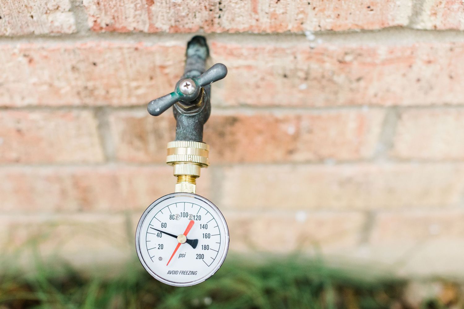 Pressure gauge attached to an outdoor faucet displaying current water pressure.